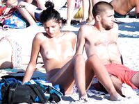 En una toalla con braguita blanca entre bañistas al sol