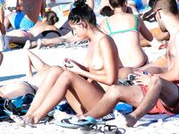 En una toalla con braguita blanca entre bañistas al sol