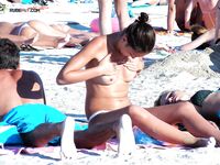 En una toalla con braguita blanca entre bañistas al sol