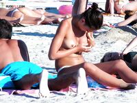 En una toalla con braguita blanca entre bañistas al sol