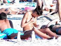 En una toalla con braguita blanca entre bañistas al sol