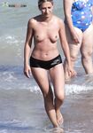 Pausa sotto l'ombrellone arcobaleno su una spiaggia nudista sabbiosa