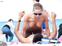 Topless Woman in Pink Bikini Bottoms at the Beach