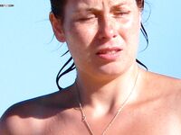 Topless Woman in Pink Bikini Bottoms at the Beach