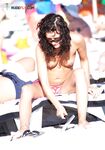 Applying Sunscreen on a Snake-Print Topless Shore