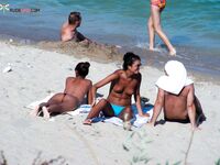 Two Women Pause at a Quiet Topless Beach Shoreline
