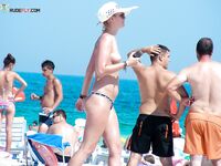 Two Women Pause at a Quiet Topless Beach Shoreline