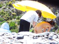 Gesprek onder zandsteenrotsen op een rustig naaktstrand