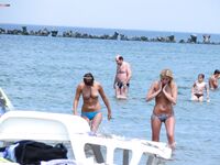 A mature nudist lady seemed very keen to hide her large beautiful breasts as she emerged from the sea. 2