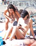 She Wringes Water From Her Hair on a Sunlit Topless Beach