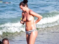 Neonowe kolczyki i wzorzysty parasol na słonecznym brzegu topless