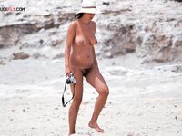 The natural beauty of a lady sunbathing topless on a quiet, sunny pier. 2