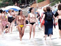 The natural beauty of a lady sunbathing topless on a quiet, sunny pier. 2