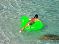 Drifting Together on a Green Inflatable Ring in Turquoise Water