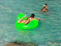 Drifting Together on a Green Inflatable Ring in Turquoise Water
