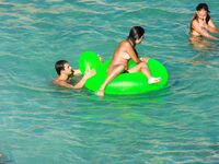 Drifting Together on a Green Inflatable Ring in Turquoise Water