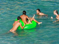 Drifting Together on a Green Inflatable Ring in Turquoise Water