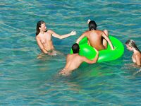Drifting Together on a Green Inflatable Ring in Turquoise Water