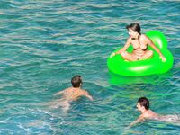 Drifting Together on a Green Inflatable Ring in Turquoise Water