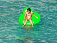 Drifting Together on a Green Inflatable Ring in Turquoise Water