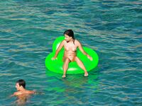 Drifting Together on a Green Inflatable Ring in Turquoise Water