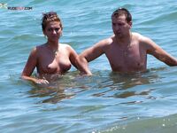 Two Adults Leaving the Water at a Topless Beach