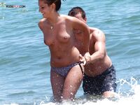 Two Adults Leaving the Water at a Topless Beach