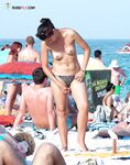 Topless in Shallow Turquoise Surf With Her Hair in a High Bun