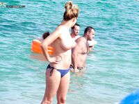 Topless in Shallow Turquoise Surf With Her Hair in a High Bun
