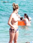 Topless in Shallow Turquoise Surf With Her Hair in a High Bun