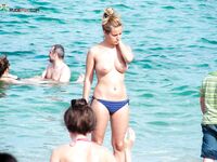 Topless in Shallow Turquoise Surf With Her Hair in a High Bun