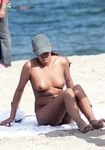 A lady enjoying the coastal breeze in a state of natural, topless relaxation. 2