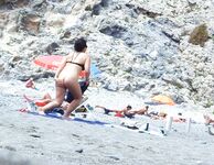 Lange grüne Luftmatratze aus der Brandung am Nacktstrand