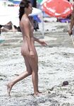 . A lady absorbed in the scenery while enjoying the warm rays in a relaxed topless fashion.