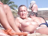 Hair Tied Back for Topless Sunbathing on a Crowded Sunny Shore