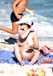 White Cap and Tan Lines Stepping From Nude Beach Surf