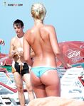 Examining a Held Item Topless on the Beach in Red-Tie Bottoms