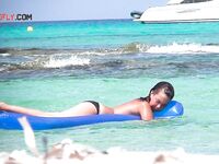 Two Bathers Share a Blue Inflatable Mat in Turquoise Shallows