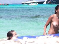 Two Bathers Share a Blue Inflatable Mat in Turquoise Shallows