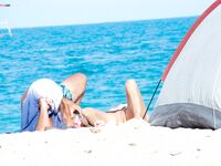 Bare Recline on Warm Sand Beside a Pitched Beach Tent