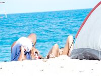 Bare Recline on Warm Sand Beside a Pitched Beach Tent