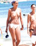 Two Women Walk the Sand in Bikini Bottoms Beside Turquoise Sea