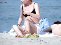 A relaxing session on a wooden pier, enjoying the heat in a classic topless fashion. 2