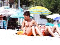Two Women Topless on the Beach in Yellow Bikini Bottoms