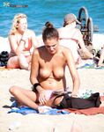 A lady enjoying the rhythmic sound of the waves in a relaxed, clothing-free manner. 2