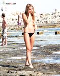 A lady enjoying the rhythmic sound of the waves in a relaxed, clothing-free manner. 2