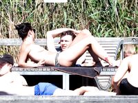 Three Nudists in a Grassy Clearing by the Foliage