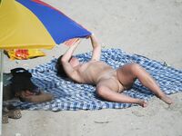 Nude Beach Stroll with Wet Hair and Silver Pendant