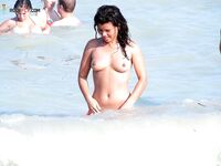 Smiling Nude Beach Walk Beside a Clothed Man in Grey and Red