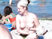 Two Nudists Standing Together by Beach Rocks